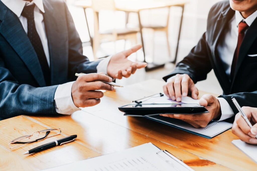 机の上のノートパソコンを見ている男性